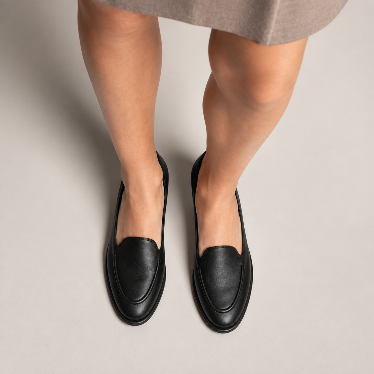 Titre SEO : Mocassin cuir noir femme porté | Description SEO : Mocassin noir porté avec tenue élégante, idéal pour un look raffiné, professionnel et confortable.