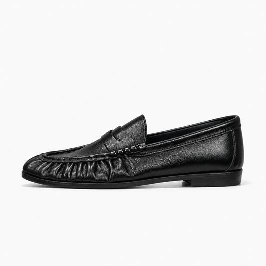 Mocassin noir femme vue de profil - Chaussure plate en cuir grainé noir avec avant froncé, bride décorative et semelle basse confortable.
