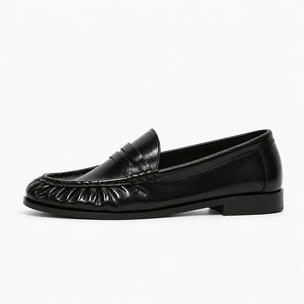 Mocassin noir femme vu de profil, cuir brillant, franges et semelle basse elegante.