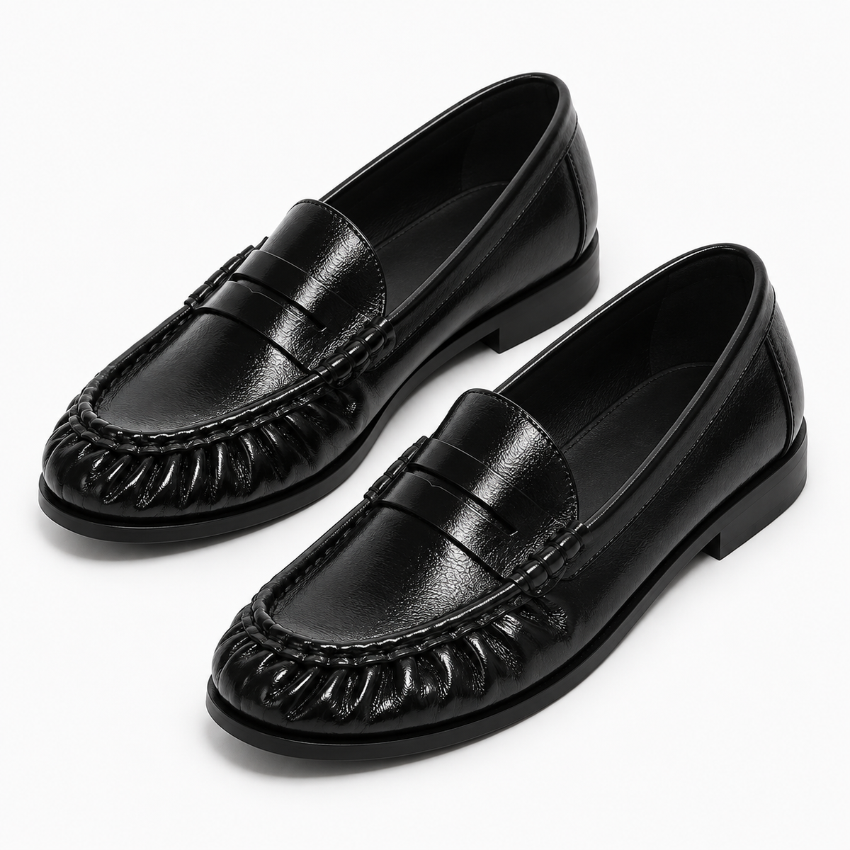 Paire de mocassins noirs femme en cuir brillant, vue trois-quarts sur fond clair.