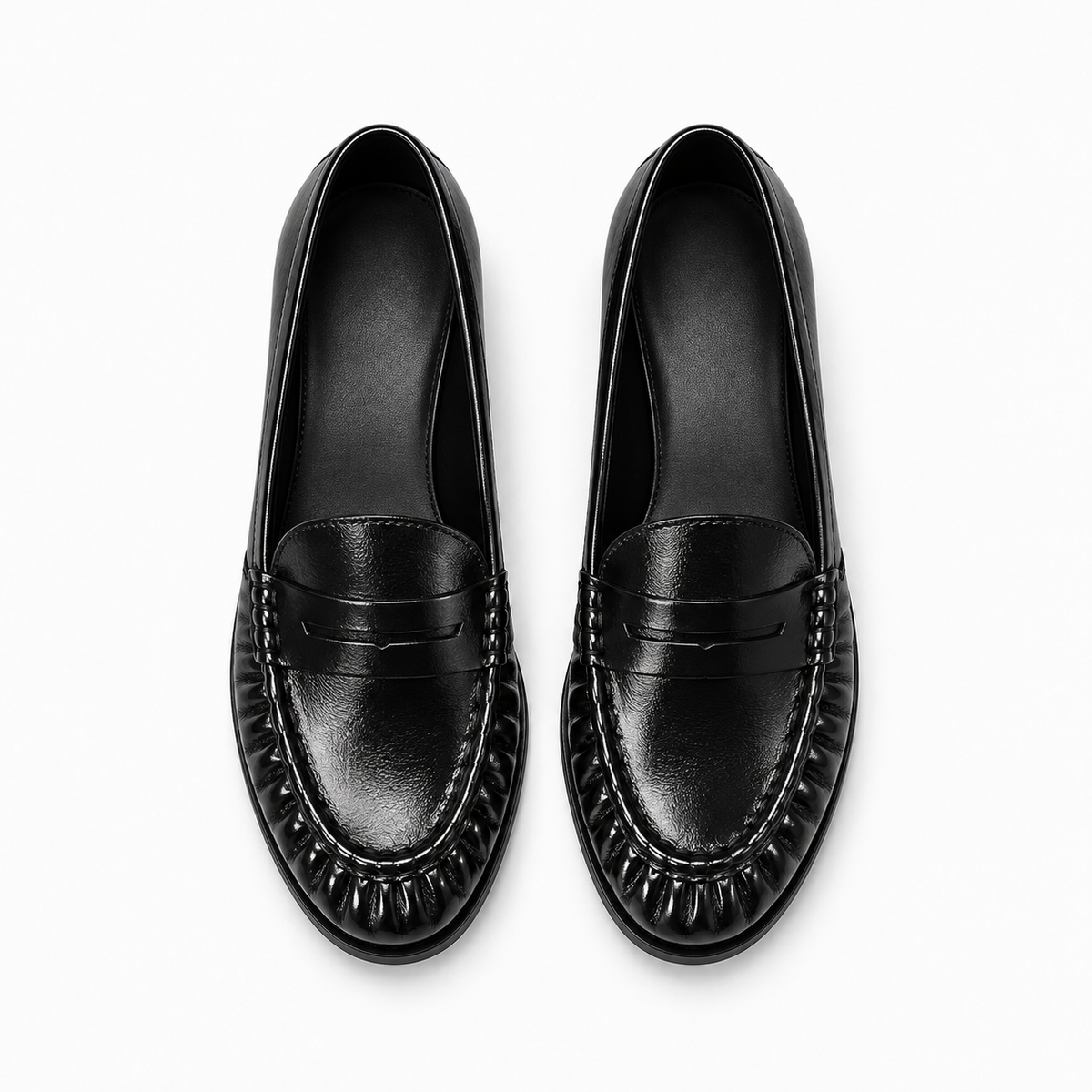 Paire de mocassins noirs femme vue du dessus, cuir brillant, franges et bride penny.
